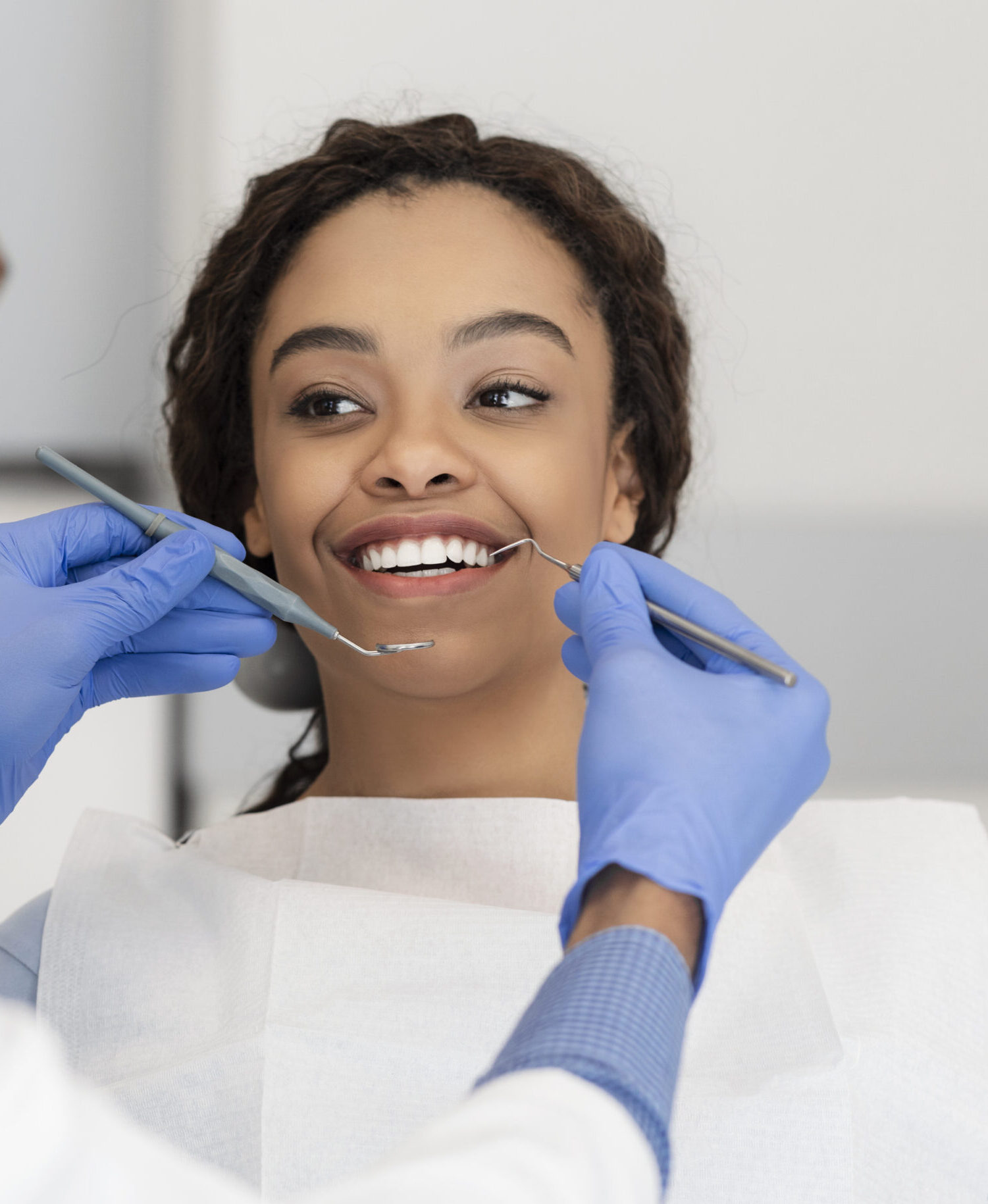 Pretty black lady looking at her dentist with smile